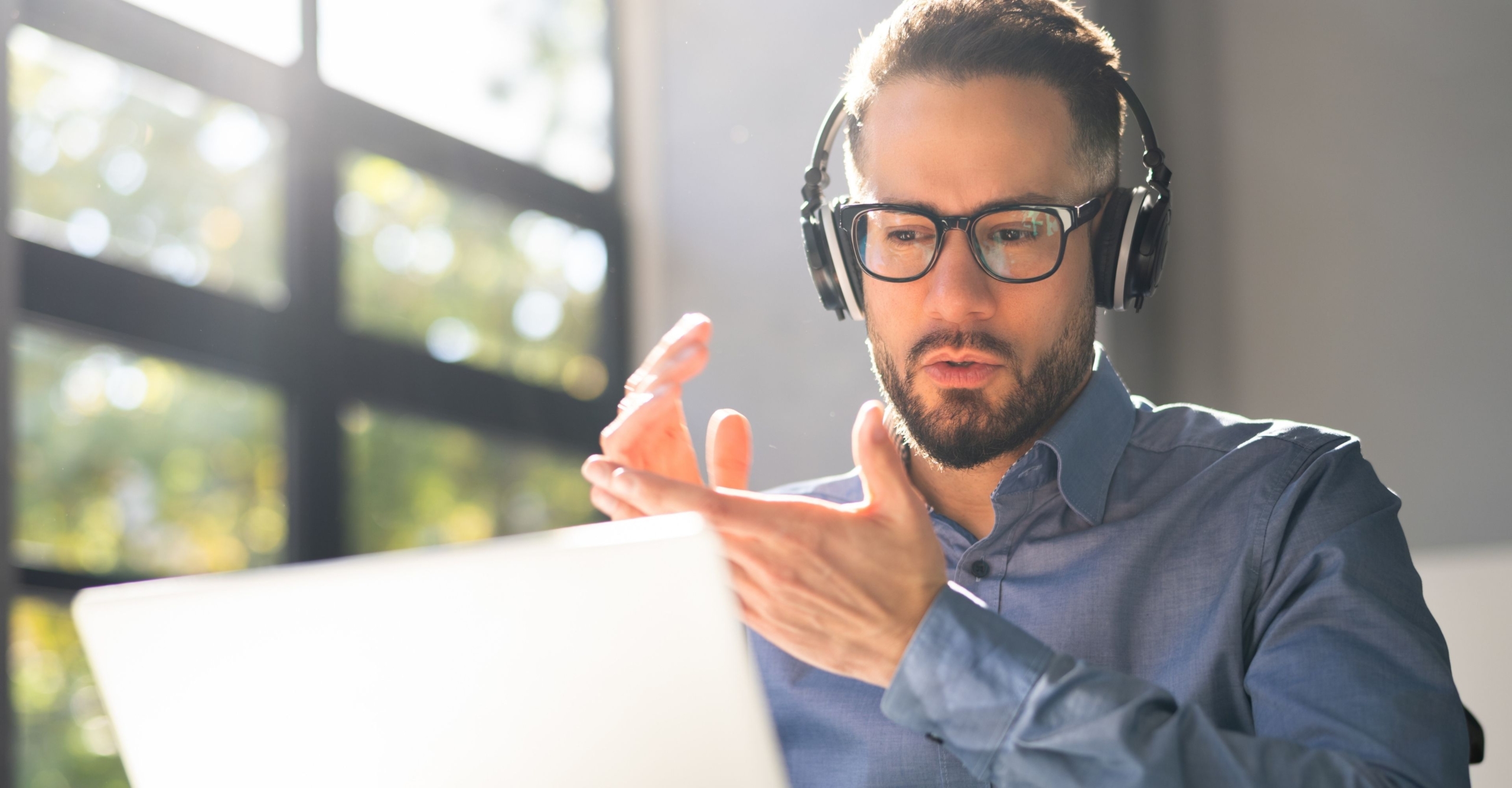 Man with a headset talking on a video work call